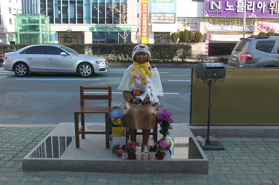 부산 일본영사관 앞에 세워진 소녀상에는 시민들이 두고 간 꽃과 음식이 가득하다.