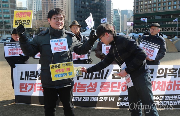 민권연대, 탄기국 관제데모 풍자 퍼포먼스 민주민생평화통일주권연대(이하 민권연대)은 10일 오후 서울 중구 서울시청광장에서 기자회견을 열어 박근혜 대통령 탄핵 기각을 위한 국민총궐기 운동본부(이하 탄기국)의 불법 점거 농성 중단과 관제 데모로 여론 조작하는 행위를 중단할 것을 촉구했다.
이날 이들은 탄기국 관제데모 의혹 풍자하며 돈을 건네주는 퍼포먼스를 벌였다.