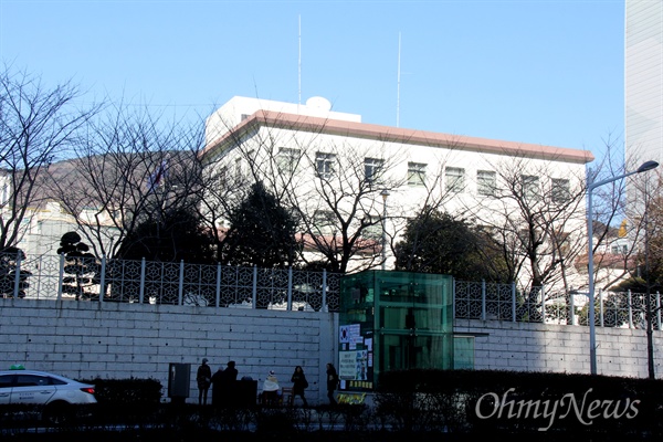  부산 일본총영사관 후문 앞에 있는 '평화의 소녀상'과 그 옆에 지하철 엘리베이터 외곽벽.