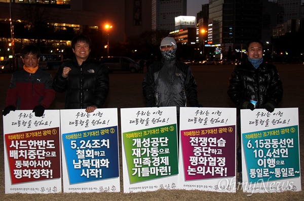 11일 오후 창원광장에서 열린 '박근혜퇴진 제15차 경남시국대회'에서 통일촌 회원들이 손팻말을 들고 서 있다.