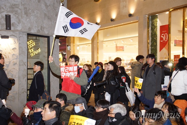 11일 오후 대구백화점 앞에서 열린 박근혜퇴진 대구시국대회에 참가한 한 시민이 '박근혜를 구속하라'는 손피켓과 태극기를 들고 서 있다.