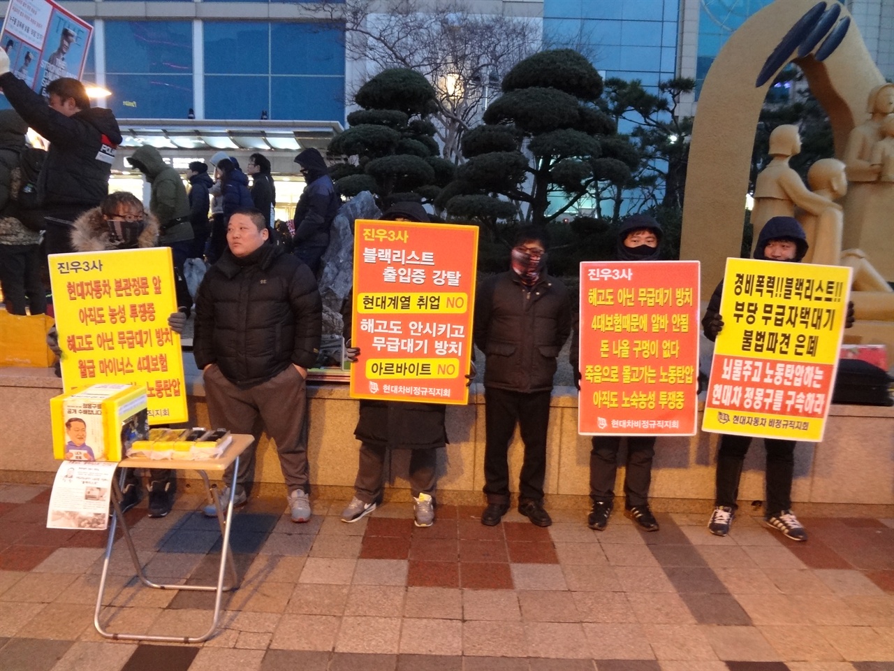 2017년 2월 11일, 울산 남구 롯데백화점에서 노동자들이 피켓을 들고 휴대전화 보조 배터리 판매를 하고 있다. 