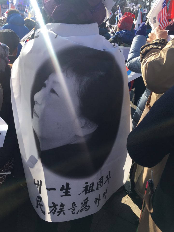 11일 '태극기 집회'에 참석한 시민이 박근혜 대통령의 사진을 넣은 천을 두르고 있다. 