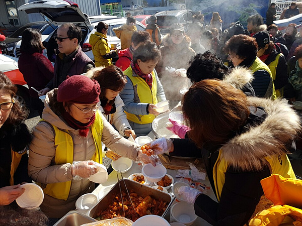 여수수산시장에 큰 불이나자 동여수노인복지관에서 운영하는 희망밥차 회원들이 피해를 입은 상인들에게 밥을 제공하고 있다