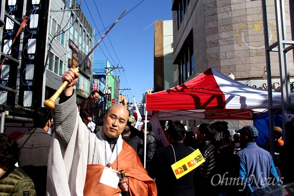  마창진 구국행동시민연합이 18일 오후 창원시 마산오동동문화거리에서 "3·15정신으로 자유대한민국을 수호하자"는 제목으로 연 '박근혜 대통령 탄핵 기각 집회'에서 호산 스님이 칼들 빼서 들어보이고 있다.