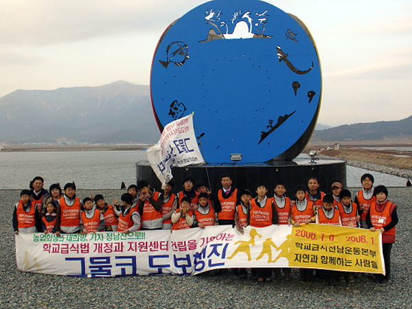  정연국 교사를 비롯한 학교급식운동본부와 용산골 자연학교 학생 30여명이 장흥 정남진 기념탑 앞에서 기념촬영했다.   2006년 1월 9일부터 담양을 떠난 그물코 도보행진팀은 7박8일간 도보행진하며 무상급식, 학교급식법 개정, 학교급식지원센터 건립을 촉구하며 지역주민들과 간담회와 서명운동을 했다.  이들이 뿌린 조그만 씨앗이 오늘의 학교 무상급식 토대가 됐다  