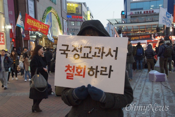 18일 오후 대구시 중구 대구백화점 앞에서 열린 '내려와라 박근혜' 대구 15차 시국대회에 참석한 한 학생이 '국정교과서 철회' 피켓을 들고 서 있다.