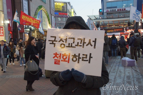  18일 오후 대구시 중구 대구백화점 앞에서 열린 '내려와라 박근혜' 대구 15차 시국대회에 참석한 한 학생이 '국정교과서 철회' 피켓을 들고 서 있다.