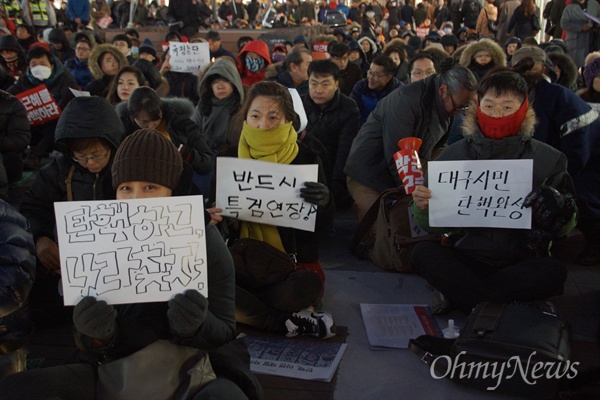 18일 오후 대구시 중구 대구백화점 앞에서 열린 박근혜 탄핵 대구시국대회에 참석한 시민들이 직접 적은 손피켓을 들고 앉아 있다.
