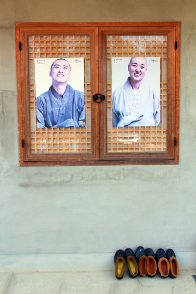 산청 심적정사 해행당에 두 스님이 반갑게 창문을 열고 반긴다. 자세히 보니 출가를 권하는 포스터다. 포스터 아래 털신이 정겹게 놓여있다.