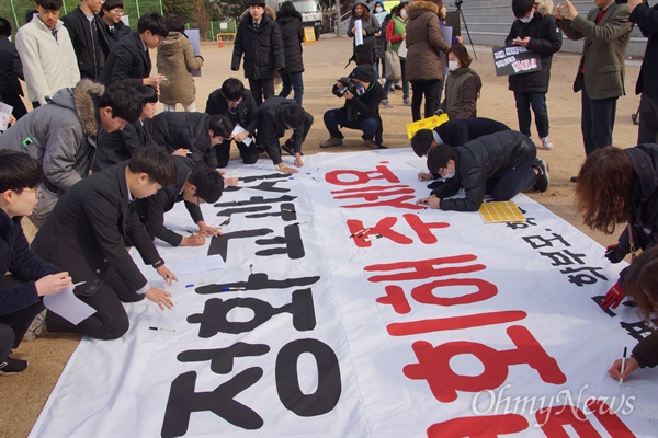 전국에서 유일하게 국정 역사교과서 연구학교로 지정된 문명고 학생들과 학부모들이 23일 오전 운동장에서 대형 현수막에 국정교과서 철회 등의 요구를 적고 있다.