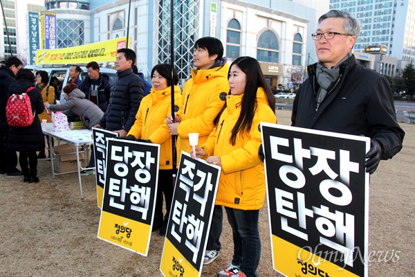 25일 저녁 창원광장에서 열린 '제17차 박근혜 퇴진 경남시국대회'에 정의당 경남도당 당원들이 손팻말을 들고 서 있다.