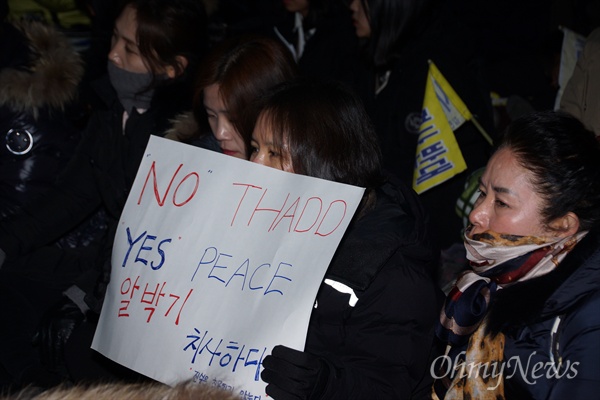 8일 오후 김천역 광장에서 열린 김천 주민들의 사드 반대 집회에 참석한 한 주민이 사드 일부 부품이 들어온 것을 비판하는 피켓을 들고 앉아 있다.