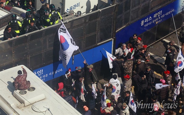 태극기로 경찰 과격하는 탄핵반대 집회 참가자들 헌법재판소가 박근혜 대통령 탄핵심판 사건의 선고 재판을 전원일치 의견으로 파면 결정한 가운데 10일 오후 서울 종로구 헌법재판소 인근에서 열린 '제20차 박근혜 대통령 탄핵기각을 위한 국민 총궐기 대회'에 참가자들이 탄핵을 인정하지 않는다며 경찰에게 태극기로 폭력행위를 하고 있다.