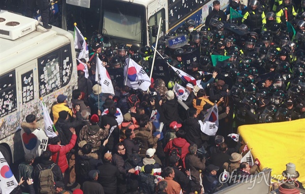 태극기로 경찰 가격, 헌재로 돌격하는 탄핵반대 집회 참가자들 헌법재판소가 박근혜 대통령 탄핵심판 사건의 선고 재판을 전원일치 의견으로 파면 결정한 가운데 10일 오후 서울 종로구 헌법재판소 인근에서 열린 '제20차 박근혜 대통령 탄핵기각을 위한 국민 총궐기 대회' 참가자들이 탄핵을 인정하지 않는다며 경찰을 태극기로 가격하며 헌재 방향으로 행진하고 있다.
