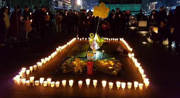 세월호 추모 모형 앞에 모인 촛불시민들이다.