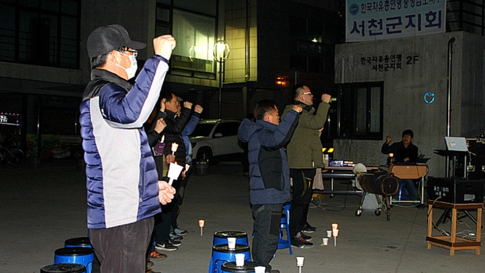  11일 서천 봄의 마을광장에서 열린 '서천군민 행동의 날'을 시작하기전 서천군민들이 '임을 위한 행진곡'을 부르고 있다.