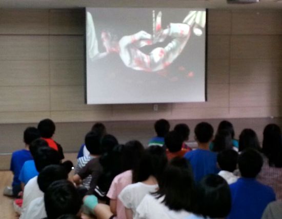 2014년 7월 17일 군부대 장교가 서울의 한 초등학교에 와서 '고문' 동영상을 보여주고 있다. 