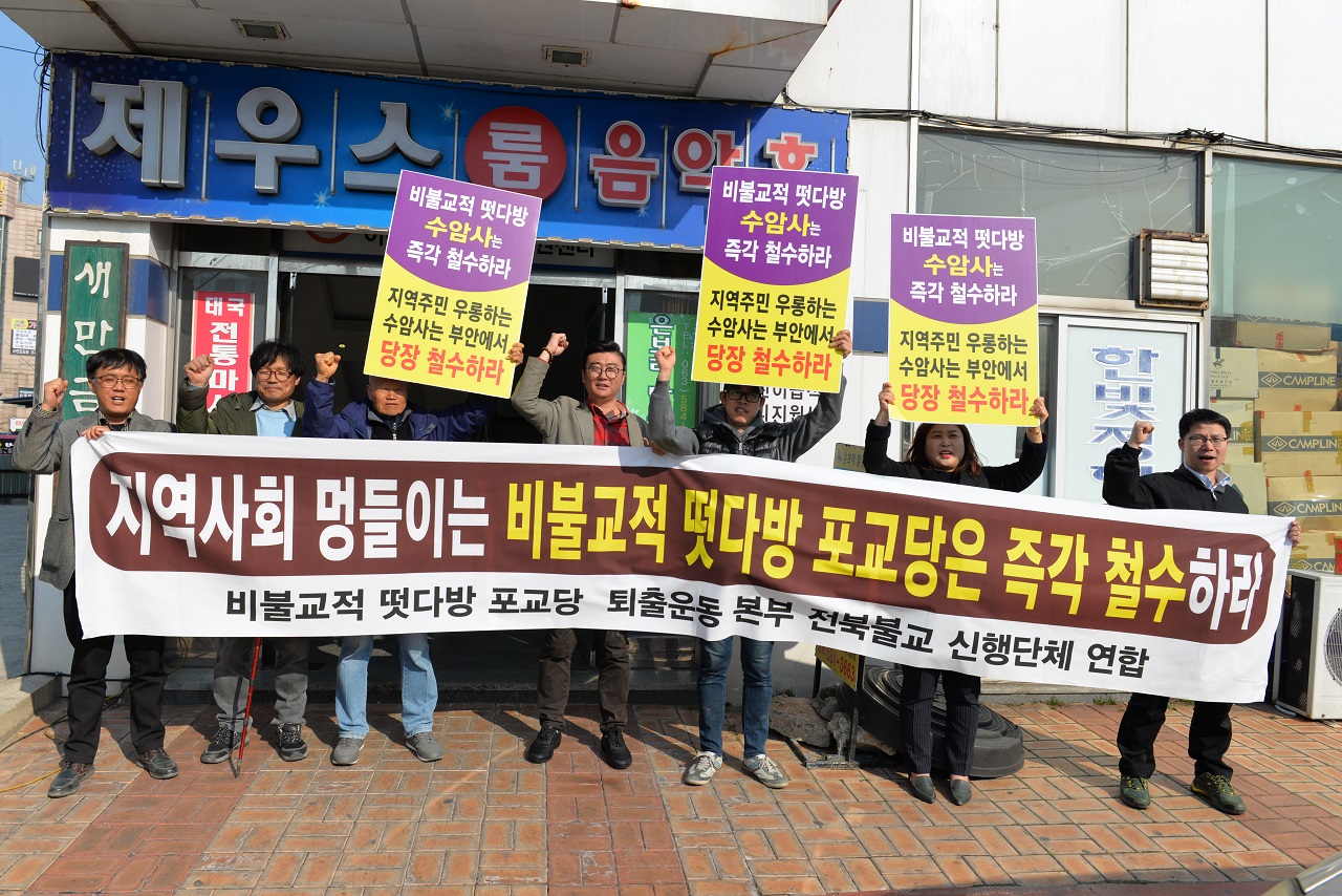 '지역사회를 멍들이는 비불교적 떳다방 포교당은 즉각 철수'를 주장하면 전대한불교청년회 전북지구 산하 부안, 전주, 김제, 정읍 지회 회원들이 항의집회를 하며 구호를 외치고 있다. 