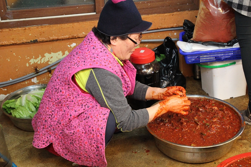 서귀포 올레시장 함평수산의 할머니가 자리돔 젓갈을 담고 있다.
