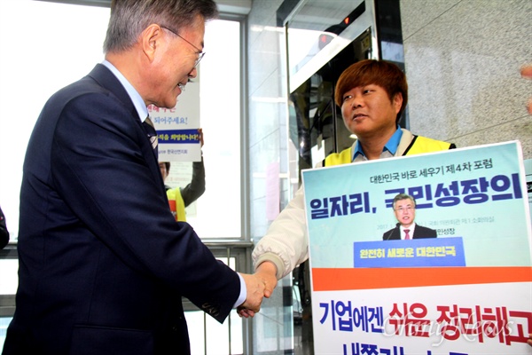 19일 오후 민주노총 경남본부를 찾은 문재인 전 더불어민주당 대표가 손팻말을 들고 서 있는 한국산연 해고노동자와 인사를 나누고 있다.