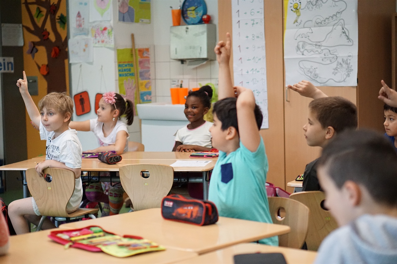 독일 헷센주 비스바덴에 있는 게슈비스터 숄 초등학교의 독일어 시간에 어린이들이 교사 질문에 답변하기 위해 서로 손을 들고 있다.