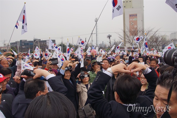  김진태 자유한국당 국회의원이 20일 오전 박정희 전 대통령 생가 앞에서 자신의 지지자들을 향해 두 손을 들어 하트 모양을 표시하고 있다.