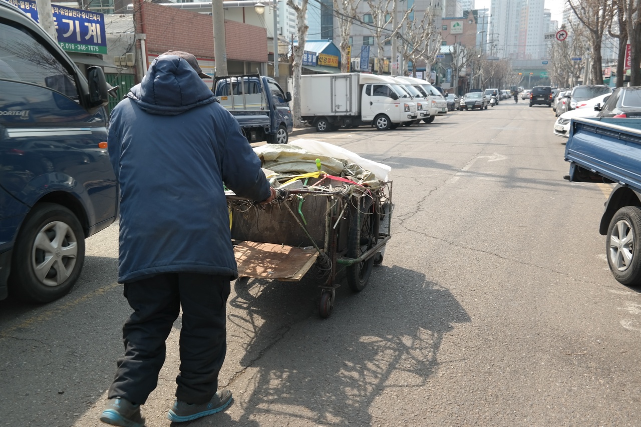 지난 16일 오전 서울 영등포구 문래동 어느 도로에서 이태평(가명·80) 할아버지가 리어카를 밀고 있다. 그 옆으로 트럭이 위태롭게 지나간다.