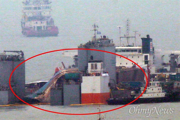 25일 오전 전남 진도군 사고 해역에서 잭킹바지선에 고박된 세월호 선체가 반잠수식 선박의 상부 메인 데크 위에 안착되어 있다.
