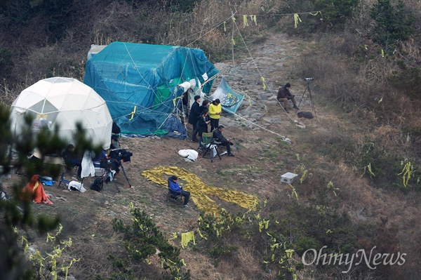 25일 오전 전남 진도군 사고 해역에서 잭킹바지선에 고박된 세월호 선체가 반잠수식 선박의 상부 메인 데크 위에 안착된 가운데, 동거차도 언덕에서 세월호참사 유가족과 취재진이 이를 지켜보고 있다.