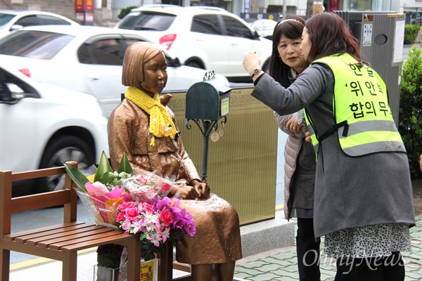 25일 부산 일본총영사관 후문 앞에 있는 '평화의 소녀상'을 찾아온 일본인이 지킴이 김민정씨로부터 설명을 듣고 있다.