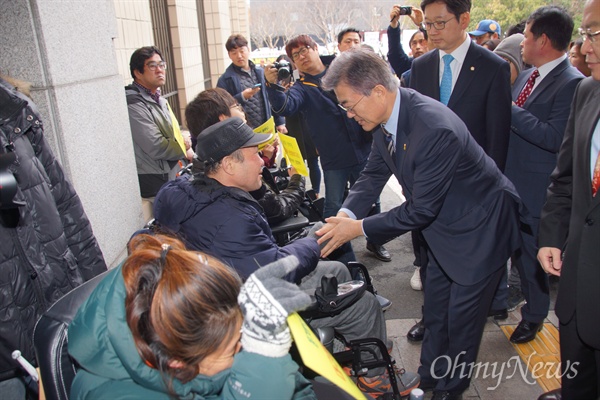 문재인 전 더불어민주당 대표가 26일 오전 대구시의회 앞에서 대구시립희망원 해결을 촉구하며 시위를 벌이고 있는 장애인단체 회원과 악수를 나누고 있다.