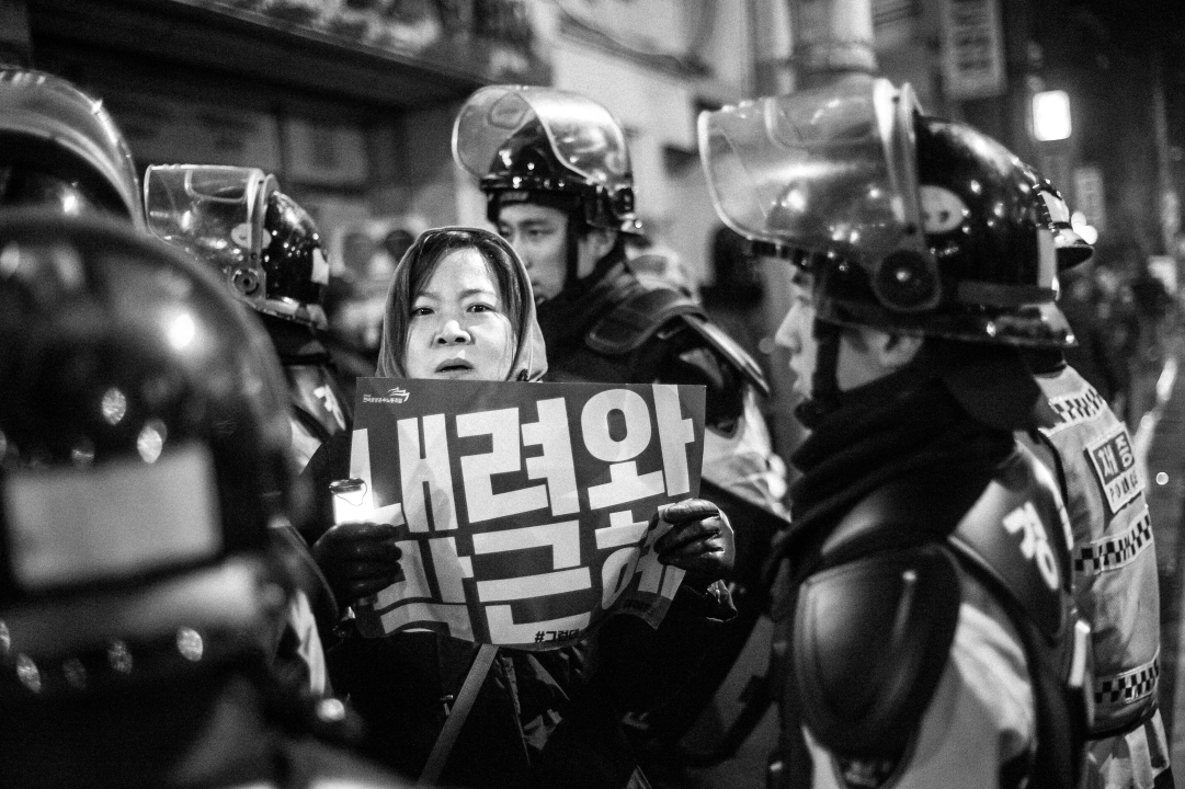2016년 11월 26일, 청운동사무소 앞 청운동사무소 앞에서 경찰 병력이 "내려와 박근혜" 피켓을 들고 있는 시민을 고착시키고 있다.