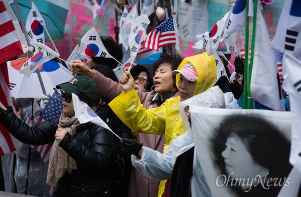 검찰이 박근혜 전 대통령의 영장을 청구한 27일 오후 서울 강남구 삼성동 박 전 대통령 자택 앞에 영장청구 소식을 들은 지지자들이 몰려와 탄핵무효를 외치며 태극기와 성조기를 흔들고 있다. 