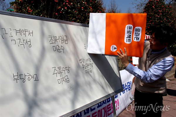 경남청년유니온은 30일 오후 창원대 앞에서 '대학가 클린존 만들기 프로젝트 선포식'을 열었고, 김지현 위원장이 벽에 '부당해고' 등의 단어를 적어놓고 지우개로 지워 없애는 퍼포먼스를 선보이고 있다.