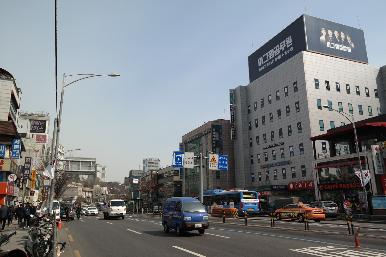 지난 3월 23일 오전 서울 지하철 1호선 노량진역 앞 도로에서 차들이 달리고 있다. 노변에는 공무원시험 준비학원 건물들이 성업 중이다.