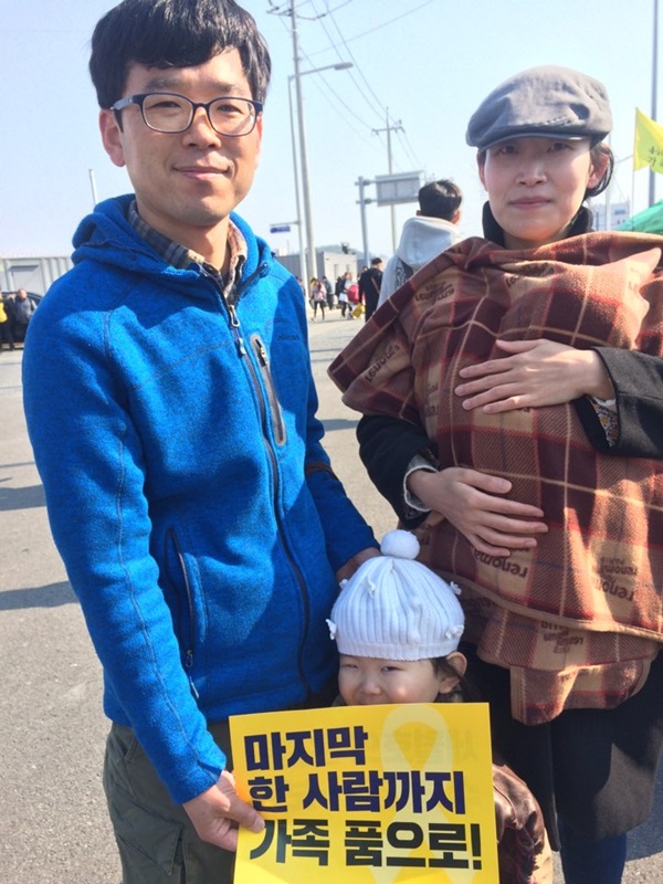 한 가족이 세월호 희생자를 추모하기 위해 목포 신항을 찾았다. 5살짜리 아이가 '마지막 한 사람까지 가족 품으로'란 구호가 적힌 피켓을 들고 있다. 