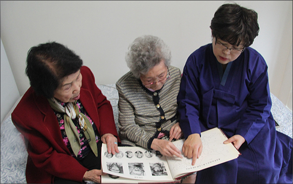  한국광복군 제3지대 앨범을 펴보이며 당시 상황을 설명하는 유순희 지사(가운데), 오른쪽 빨간 웃옷차림은 오희옥 지사로 이들 생존 독립운동가들의 이야기를 기자가 꼼꼼히 새겨듣고 있다.

