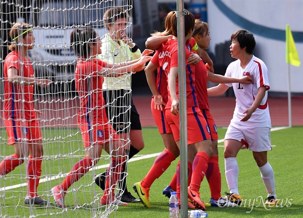  여자축구 대표팀 선수들이 7일 평양 김일성경기장에서 열린 남북한 여자축구 아시안컵 예선전에서 김정미를 차징한 북한 김평화와 몸싸움을 벌이고 있다.