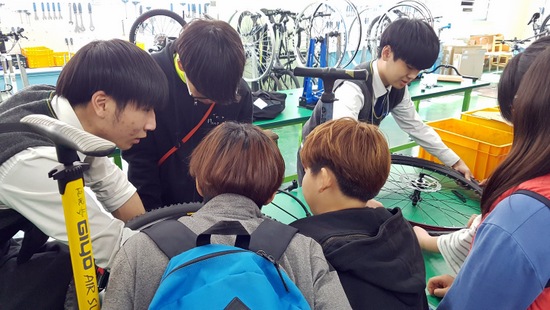 성수공고 문형철 군(맨 왼쪽)이 초등학생들에게 '자전거 바람 넣는 법'을 가르치고 있다. 