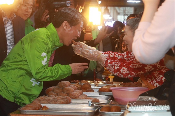 안철수 국민의당 대선후보가 17일 오후 광주 서구 양동시장을 방문하자, 한 상인이 안 후보 입에 도넛을 넣어주고 있다.