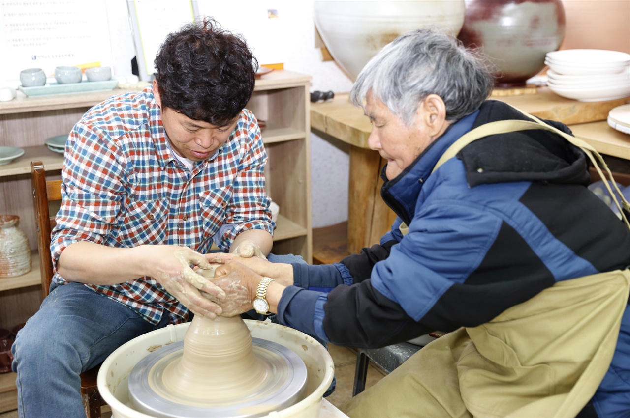 김성관 씨가 도예체험을 온 할머니를 대상으로 체험프로그램을 운영하고 있다.
