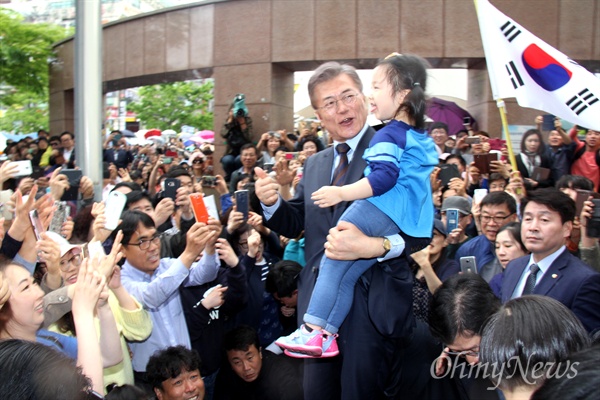 더불어민주당 문재인 대선후보가 22일 오후 창원 상남동 분수광장에서 유세를 하기 위해 들어서면서 한 아이를 안아보이고 있다.