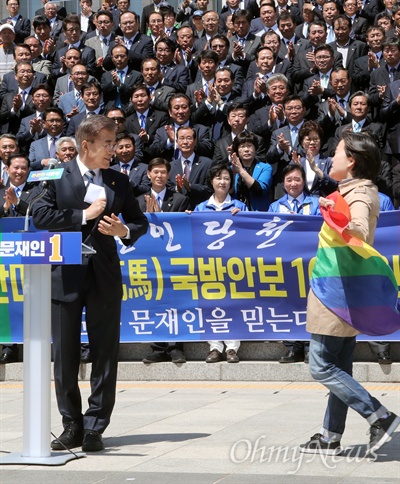 문재인 더불어민주당 대선후보가 지난 26일 오전 국회 본관 앞 계단에서 열린 ‘천군만마(千軍萬馬) 국방안보 1000인 지지선언’ 기자회견에서 인사말을 마친 직후 성소수자 단체로부터 거센 항의를 받고 있다. 레인보우 깃발을 들고 문 후보를 향해 기습시위를 벌인 이들은 전날 TV토론에서 "동성애 반대 뜻을 밝힌 것에 대해 문 후보의 사과를 촉구했다. 
