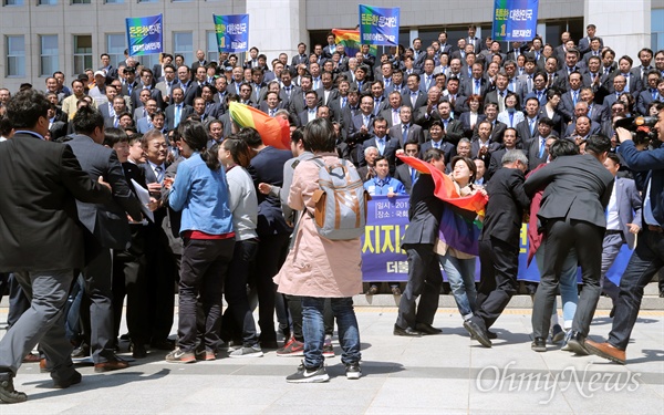 지난 4월 26일, 당시 문재인 더불어민주당 대선후보가 국회 본관 앞 계단에서 열린 '천군만마(千軍萬馬) 국방안보 1000인 지지선언' 기자회견에서 인사말을 마친 직후 성소수자 단체로부터 거센 항의를 받는 모습. 레인보우 깃발을 들고 문 후보를 향해 기습시위를 벌인 이들은 전날 TV토론에서 동성애 반대 뜻을 밝힌 것에 대해 문 후보의 사과를 촉구했다. 