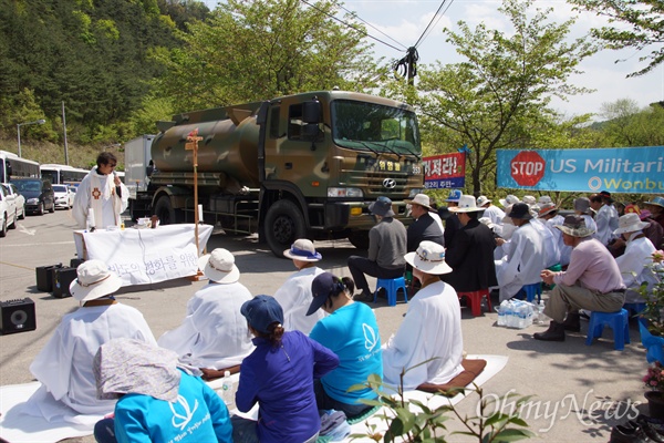 지난 22일 원불교 고무들과 천주교 사제단, 신도들이 함께 성주 골프장 안으로 들어가려던 유류트럭을 막고 기도회를 갖고 있는 모습.