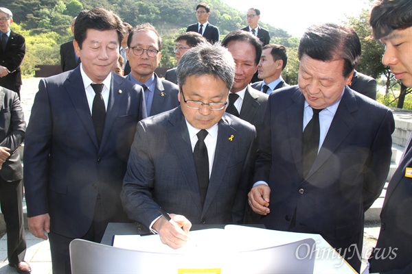 강기정 국회의원 등이 28일 오전 고 노무현 전 대통령 묘소를 참배한 뒤 방명록에 서명하고 있다.