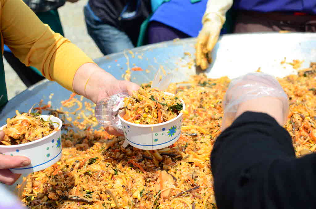 제2회 강원 산나물한마당에서 퍼포먼스로 비벼진 산나물 비빔밥을 나눠주고 있다.