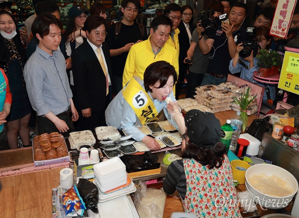 떡 받아 먹는 심상정 후보 심상정 정의당 후보가 3일 오후 강원도 춘천시 중앙로 명동길에서 유세를 하며 한 상인이 건네는 떡을 먹고 있다.