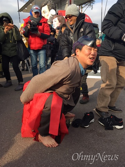  풍물패 삶터의 이성호씨가 11일 오후 박근혜 정권의 블랙리스트 사태에 저항하며 '블랙리스트 칼날' 위에 올라가 익살 맞은 표정을 짓고 있다. 이성호씨 역시 블랙리스트에 올랐다. 